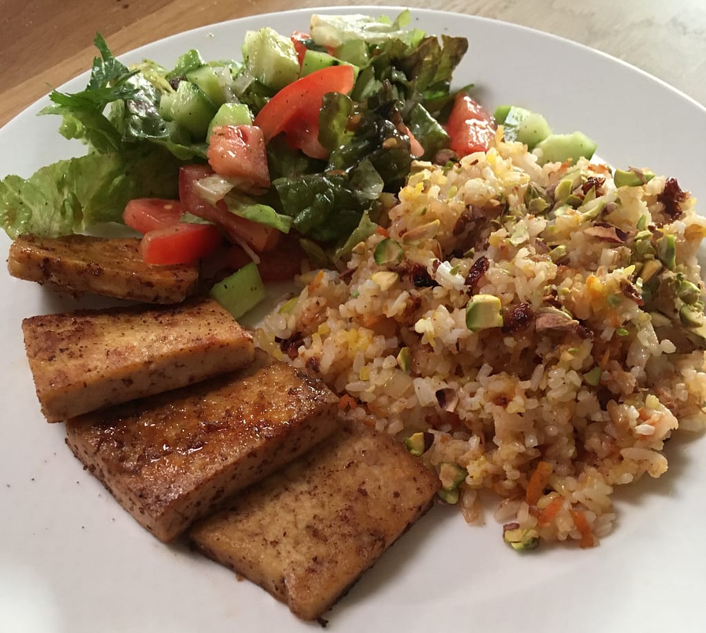 tofu cutlets with barberry rice and a green salad with cucumber and tomatoes