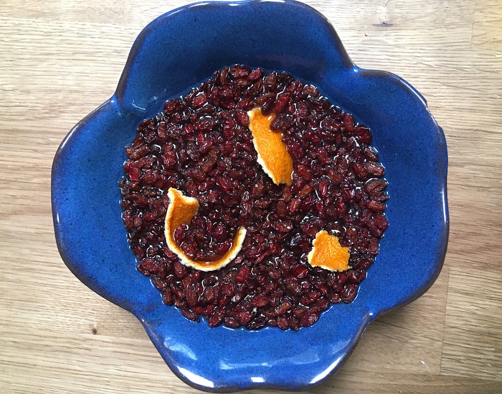 barberries and orange peel in a blue bowl