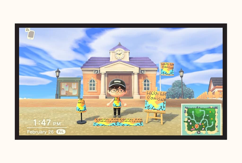 An avatar of a boy in Animal Crossing stands in front of town hall displaying the When We Vanished pixel art that was created to mimic the cover. It is being modeled on the flag outside the building, a canvas on an easel, a rug on the ground, and on a T-shirt the character is wearing.