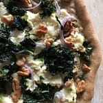 olive-oil-based pizza with vegan ricotta, kale, shallots, and walnuts