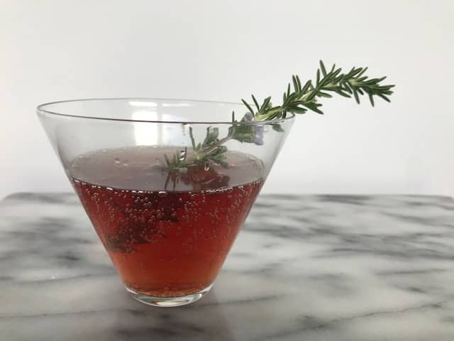 pomegranate mocktail with a sprig of rosemary