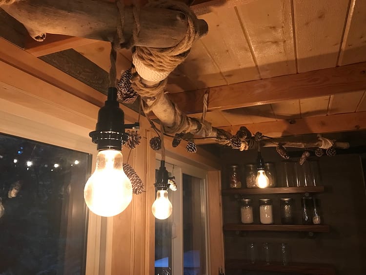 a string of lightbulbs inside a wood-ceilinged kitchen